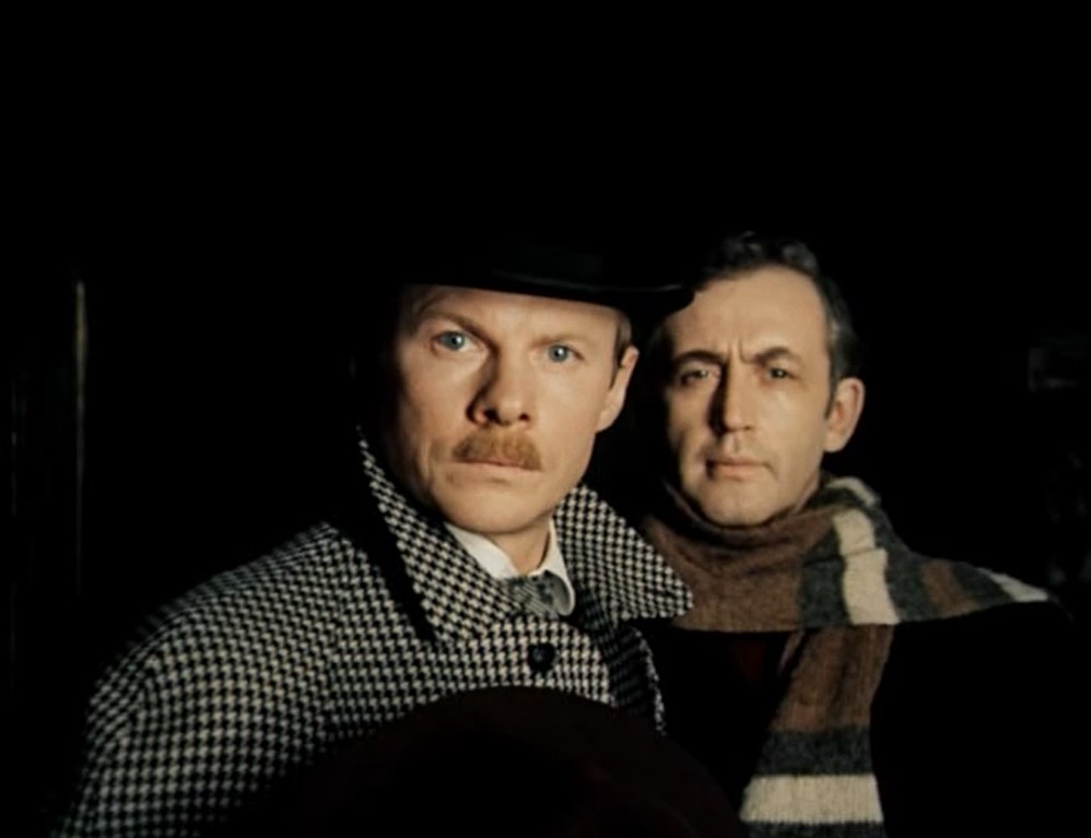 [Ватсон видит воскового Холмса в окне их дома напротив]
— Неплохо придумано, правда?
— Что это?
— Произведение искусства. Работа скульптора Менье из Гренобля. Он делал эту восковую фигуру две недели.
— Зачем?
— Чтобы они думали, что я там, в то время, как я здесь.
— Кто?..
— Вы что забыли, что за нашим домом следят?
— Кто?..
— Очаровательная компания, глава которой покоится на дне Рейхенбахского водопада.
— Смотрите, он... живой...
— Ну разумеется...
[сцена Майкрофта и Хадсон, которые ползают под столом и двигают восковую фигуру]