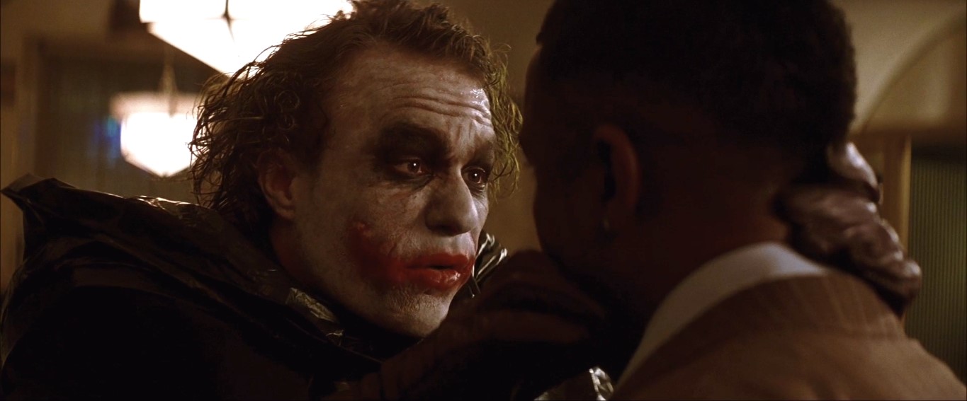 Хочешь знать, откуда эти шрамы? Мой папаша был алкаш и изверг, и однажды он взбесился больше обычного. Мамочка схватила кухонный нож, чтобы себя защитить, но папочке это не понравилось! И вот у меня на глазах он её зарезал, хохотал как сумасшедший. Потом повернулся и говорит: «Чего ты такой серьёзный, сынок?» Он шёл на меня с ножом... «Чего ты такой серьёзный, сынок?!» Он вставил мне лезвие в рот: «Давай-ка мы тебе нарисуем улыбку!» И... «Чего ты такой серьёзный?»